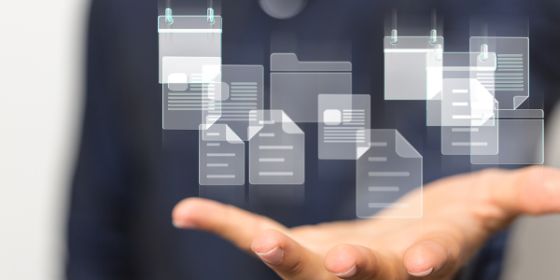 Imagen de una mano abierta hacia arriba con fichas de carpetillas difuminadas en suspensión por encima de esa mano