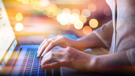 Imagen de unas manos de mujer utilizando un ordenador portátil