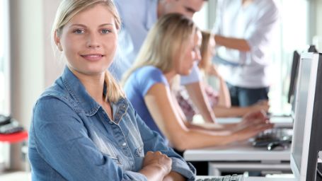 La fotografía muestra mujeres en una sala con ordenadores.