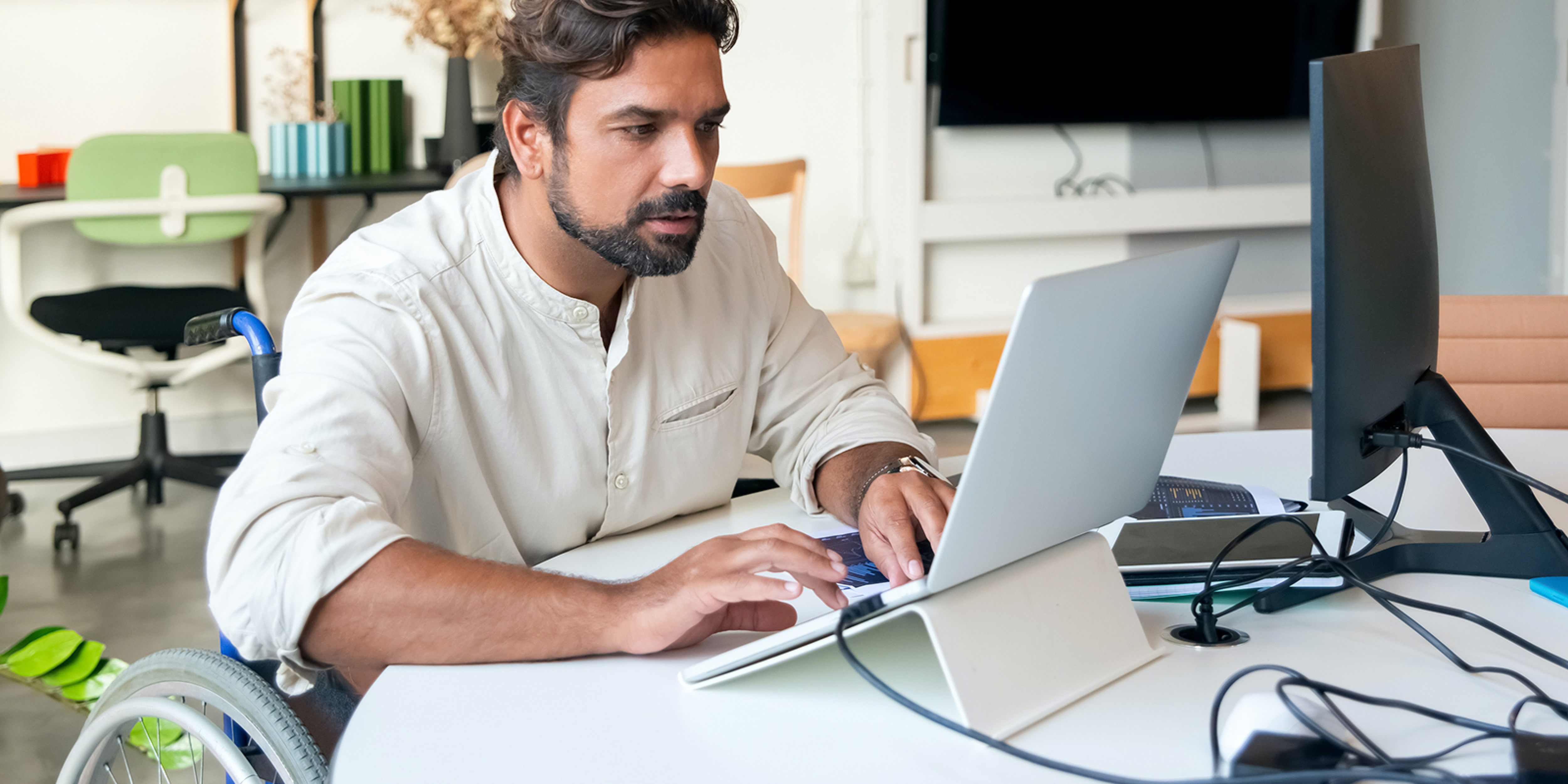 Imagen de una persona en silla de ruedas frente a un ordenador