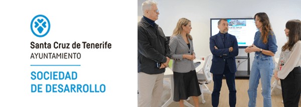 Imagen con el logotipo de sociedad de desarrollo de santa cruz de tenerife, a la izquieda, y a la derecha, imagen de cinco personas reunidas de pie,  charlando con un proyector al fondo.